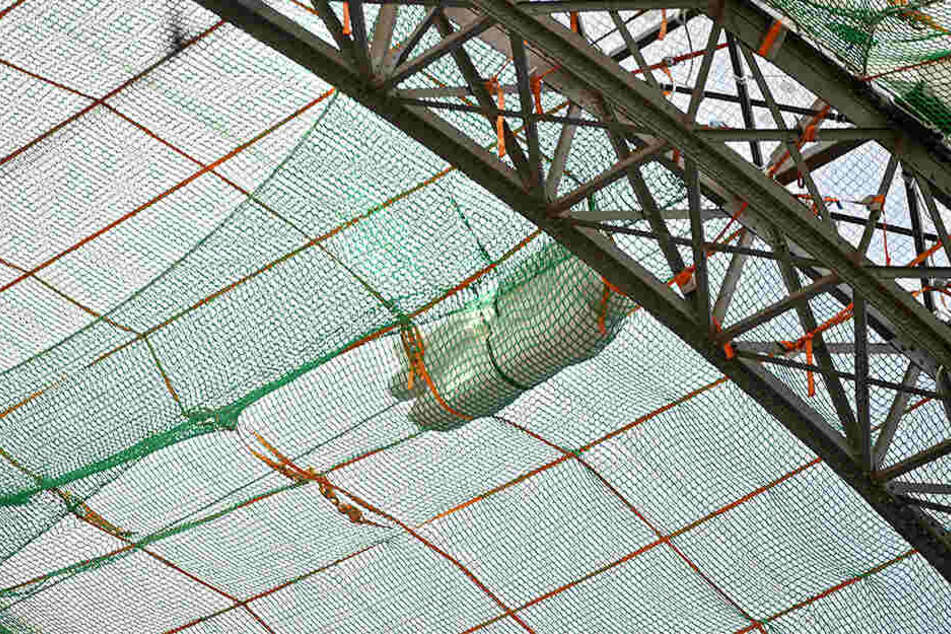 Diese grüne Plattformnetzen mit den orangenen Gurten können Arbeiter begehen und so die textile Dachhaut austauschen.