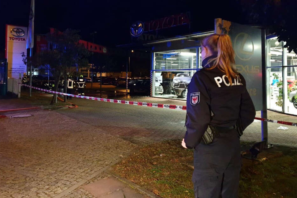 Eine Polizistin steht vor dem Autohaus.