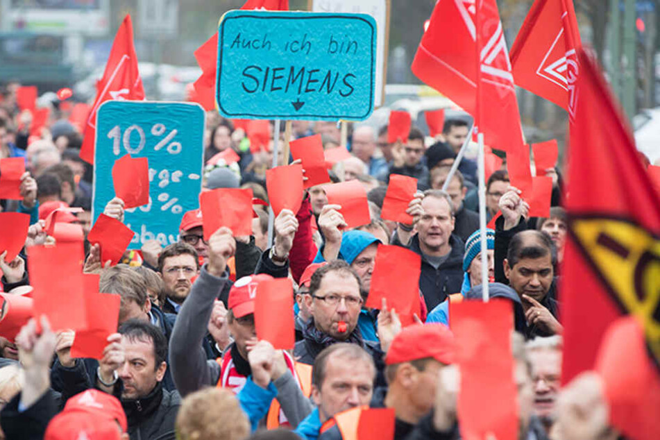 Die Rote Karte für Siemens-Chef Joe Kaeser halten in Offenbach (Hessen) Beschäftigte der Siemens-Niederlassung Offenbach gegen einen geplanten Stellenabbau in die Höhe.