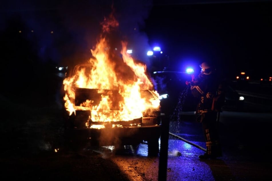 Ein Feuerwehrmann versucht den Fahrzeugbrand mit spezieller Ausrüstung einzudämmen.