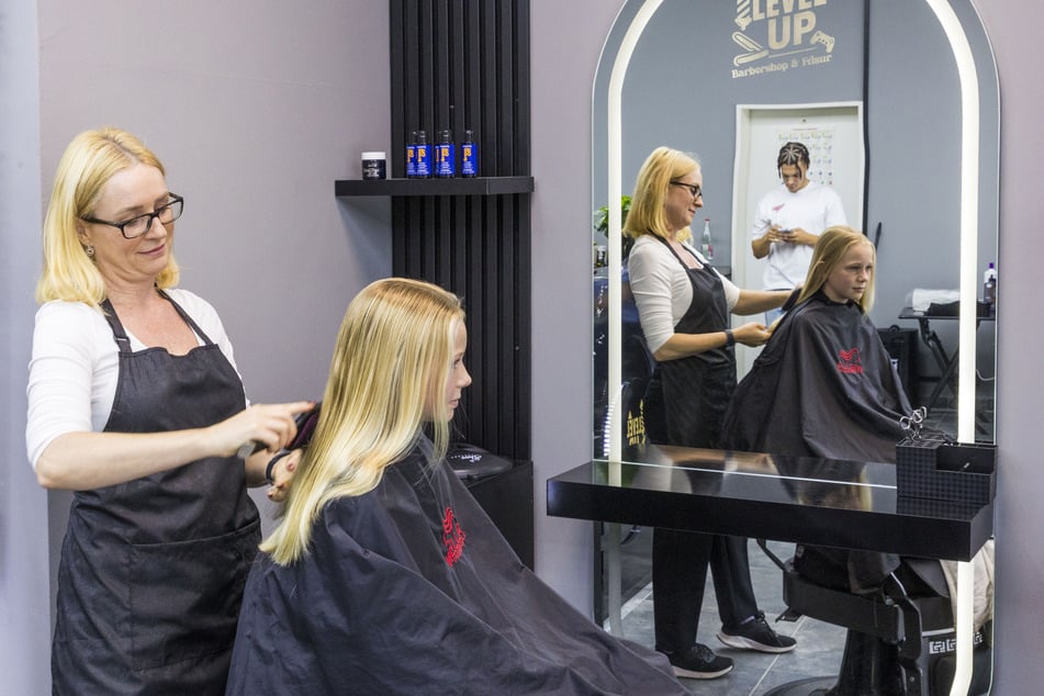 Friseurmeisterin Sabrina Löffler (44) schneidet Sofia (10) die langen blonden Haare.