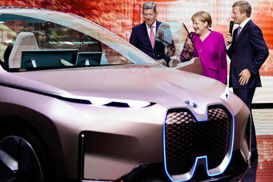 Mattes (li.) mit Bundeskanzlerin Angela Merkel (CDU) und dem Vorsitzenden des Vorstands der BMW AG am Stand von BMW bei der IAA.