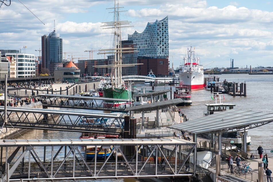 Die Hamburger Landungsbrücken mit der Elbphilharmonie im Hintergrund. Die Corona-Inzidenz ist in der Hansestadt auf 63,0 gesunken. (Archivfoto)