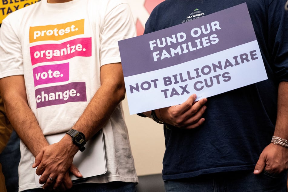 Demonstrators hold signs during a Capitol Hill press conference opposing cuts to Medicaid, the Supplemental Nutrition Assistance Program, and the Child Tax Credit.