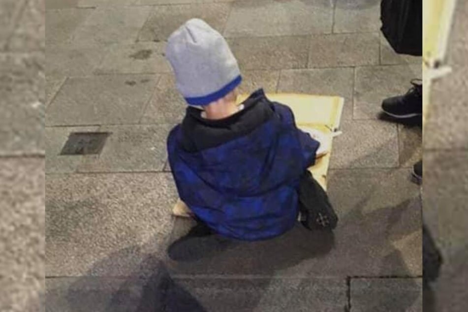 Obdachloser Junge (5) isst Nudeln von Pappkarton