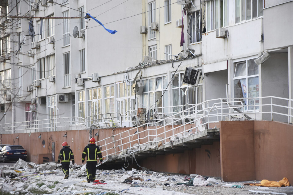 Feuerwehrleute stehen vor den Trümmern eines Wohnhauses in Odessa.
