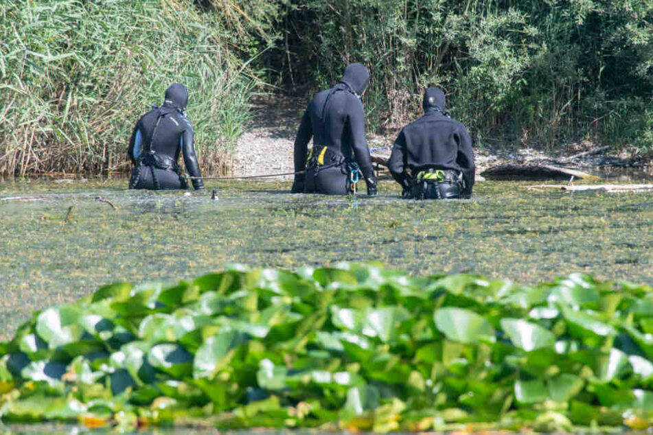 Taucher der Polizei suchen im Baggersee im alten Kieswerk bei München nach zwei Leichen.