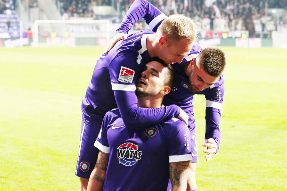 Pascal Testroet (M.) kniet nach seinem Treffer zum alles entscheidenden 3:1 auf dem Rasen, lässt sich von Marko Mihojevic (r.) und Florian Krüger feiern.