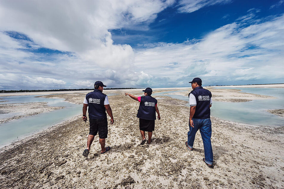 World Health Organization workers in a coastal area, one of the types of regions already getting hit by the effects of climate change.