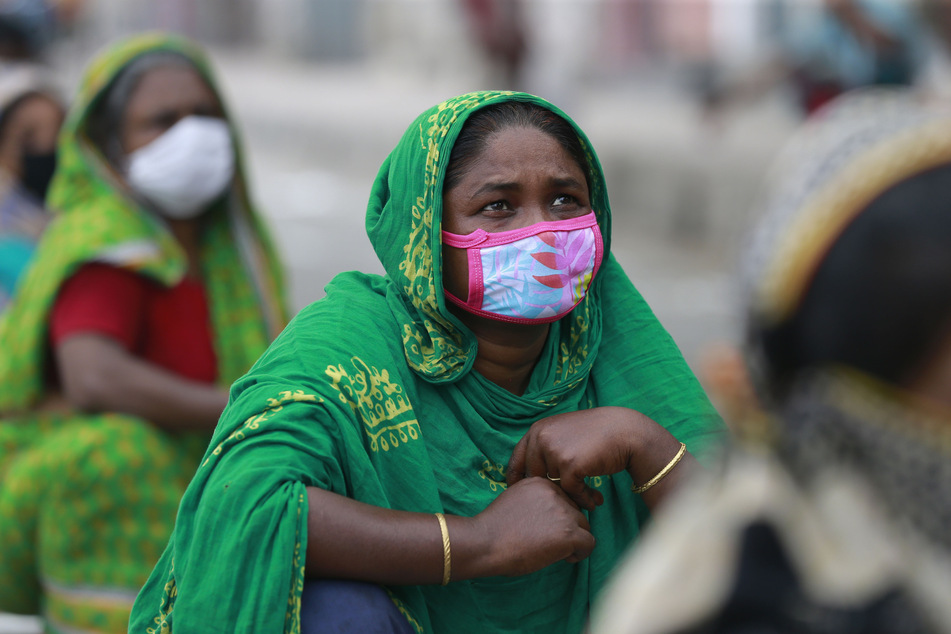 Obdachlose in Bangladesch, die als Maßnahme zur Eindämmung des Coronavirus einen Mundschutz tragen, warten auf Hilfsleistungen.