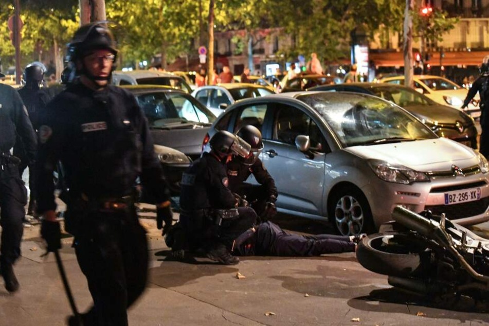 In Paris nehmen Polizisten randalierende Fans fest.