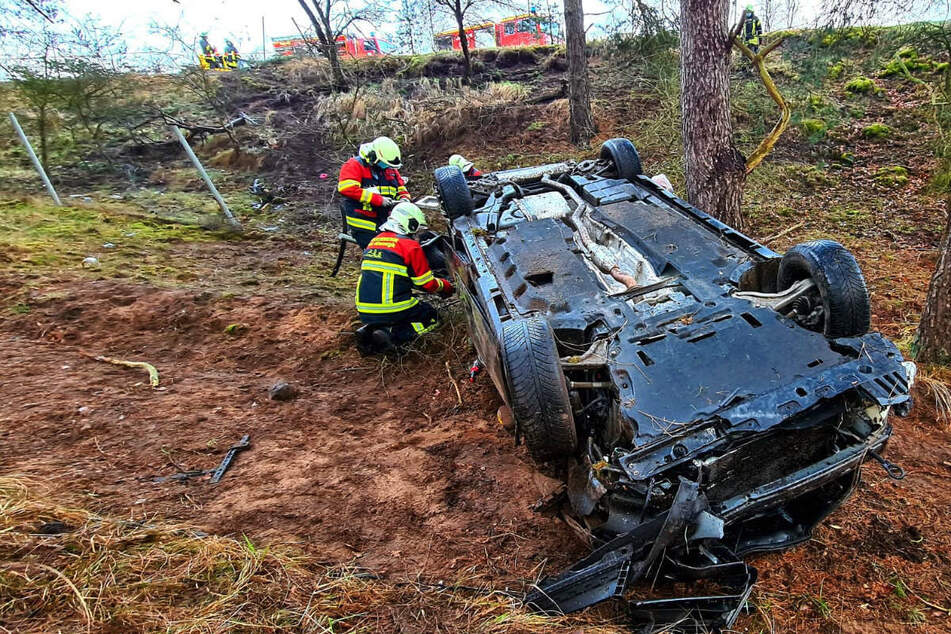 Mitarbeiter der Feuerwehr untersuchen das Wrack.