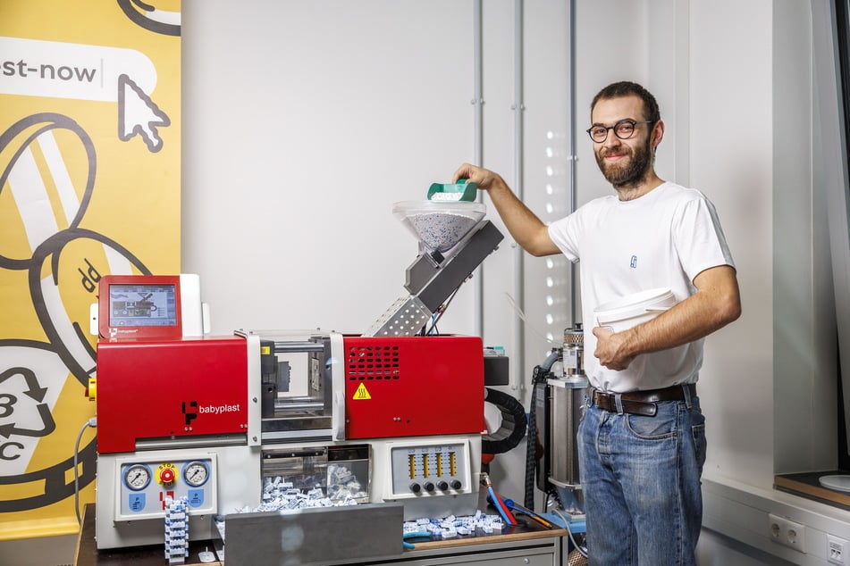 Aus dem Granulat wird mithilfe einer Spritzgussmaschine neues Spielzeug, wie Holypoly-Mitarbeiter Jakob Reck (29) demonstriert. Hier sind es Plastebausteine.