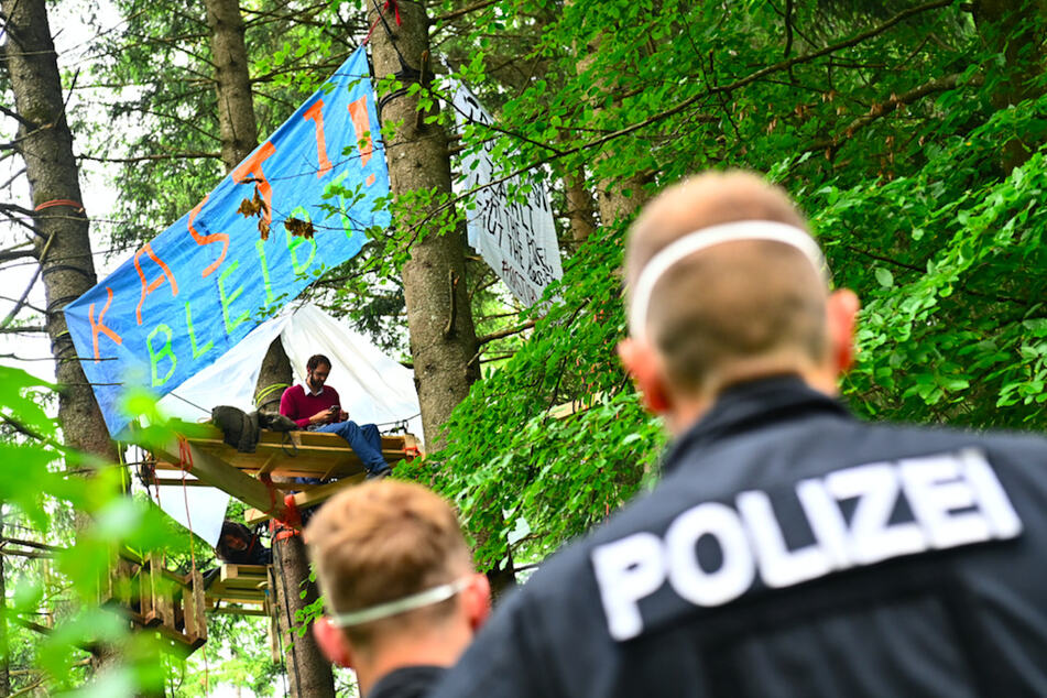 Polizisten stehen am Rande des Protestcamps im Forst Kasten nahe München.