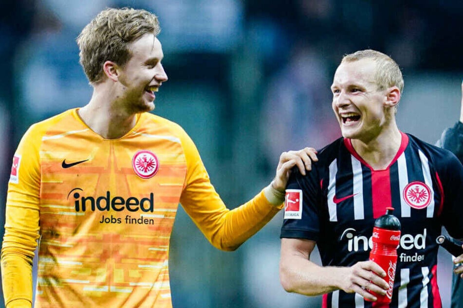 Frederik Rönnow (li.) freut sich mit Sebastian Rode (re.) über den 3:0-Sieg von Eintracht Frankfurt über Bayer Leverkusen.