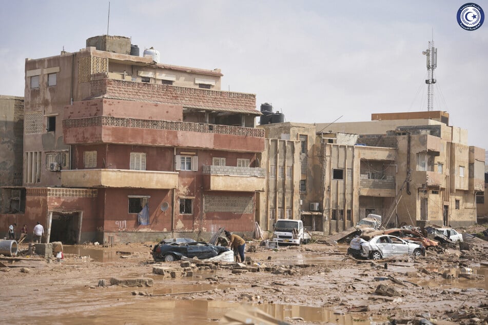 Autos und Trümmer in einer Straße in Darna, nachdem diese durch starke Regenfälle überflutet wurde.