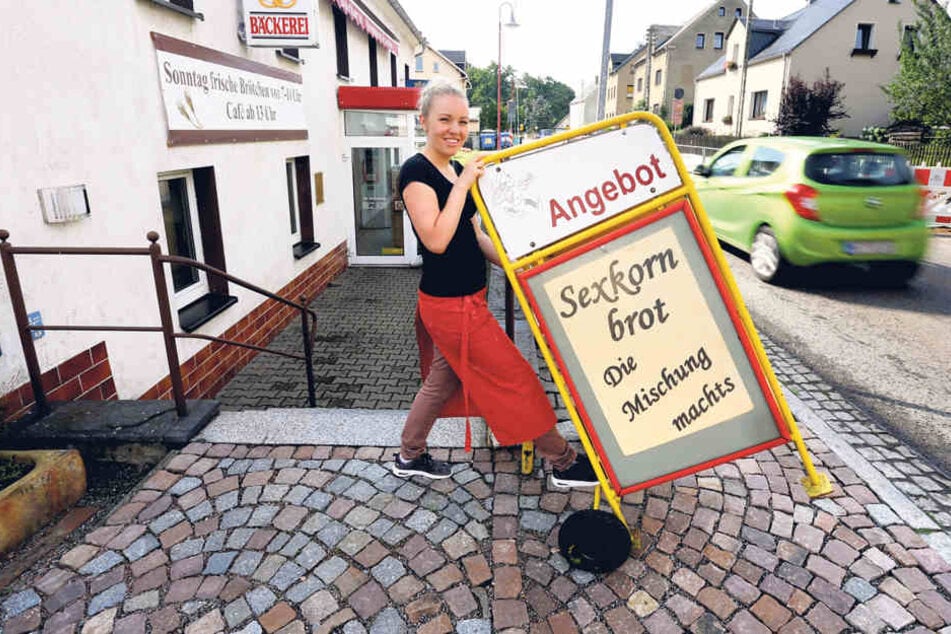 Sexkornbrot im Angebot! Franziska Müller schiebt einen Werbe-Aufsteller vor 
die Tür der Bäckerei.