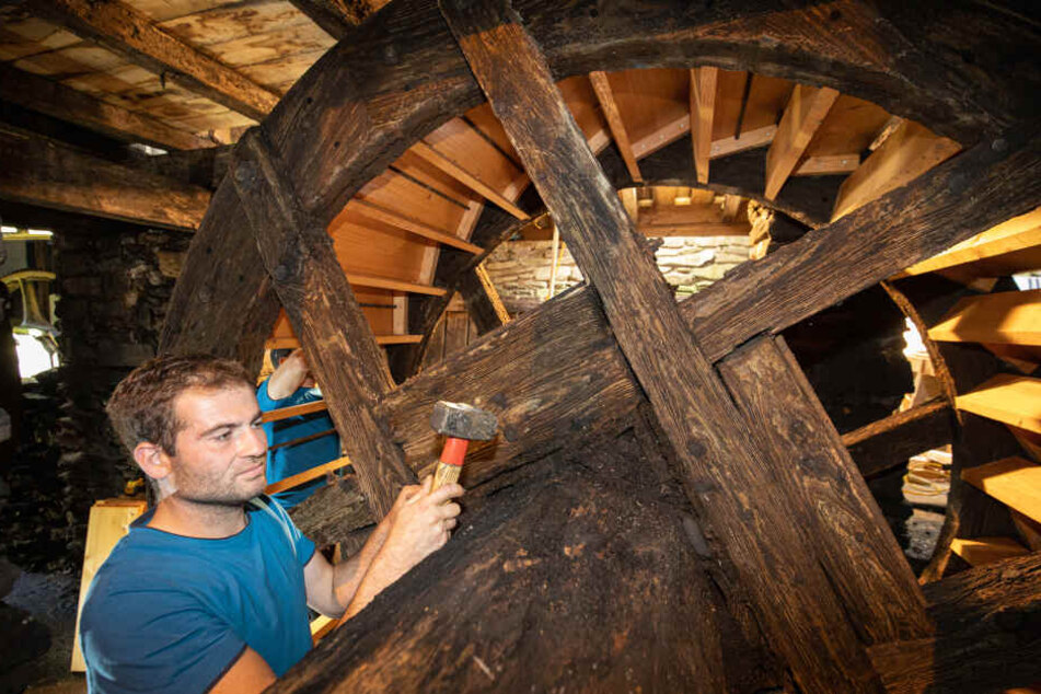 2014 und 2019 haben die Mühlenbauer aus Mulda das Wasserrad am Frohnauer Hammer erneuert. Hier schlägt Patrick Einenkel einen Bolzen ein.