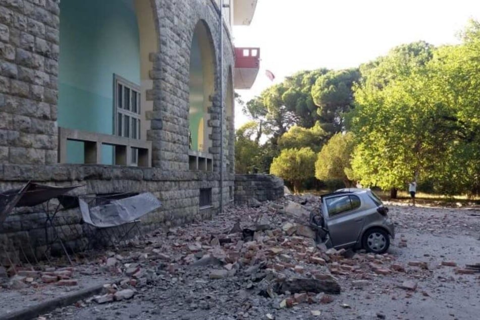 Ein beschädigtes Auto liegt nach einem Erdbeben unter den Trümmern vor dem Gebäude der Geologie-Fakultät.