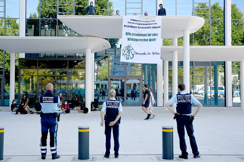 Eine Gruppe von Klimaaktivisten protestiert mit einem Transparent vor der Zentrale des Zementherstellers HeidelbergCement.