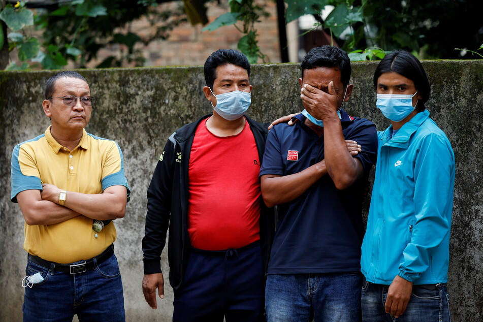 Relatives of victims of the plane crash wait for their loved ones' bodies at a morgue in Kathmandu.