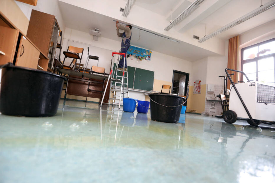 In den Zimmern sind Eimer aufgestellt, um das Wasser, das durch die Decke tropft, aufzufangen. Auf dem Boden stehen noch Pfützen.