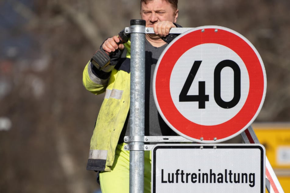Ein Mitarbeiter der Stadt montiert eines der neuen Tempo 40-Schilder in Stuttgart.