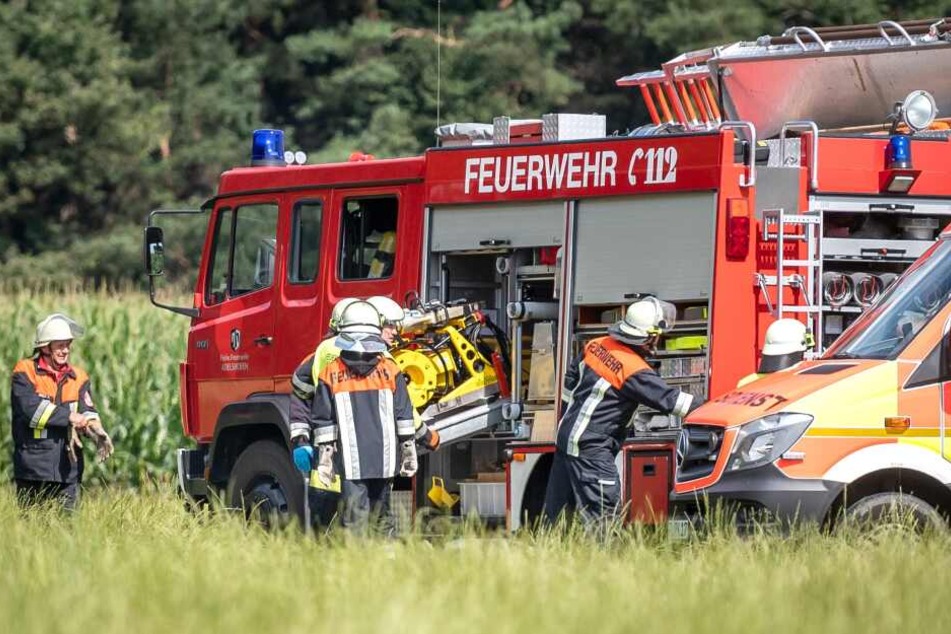 Einsatzfahrzeuge stehen an einem Feld. Beim Absturz eines Kleinflugzeugs westlich von München ist der Pilot ums Leben gekommen.