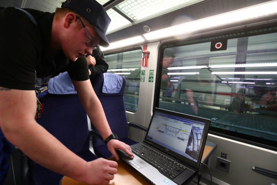 Markus Aßmann überprüft an einem Laptop die Heizungsanlage in einem IC im Leipziger ICE-Werk bei der Inspektion und Wintervorbereitung.