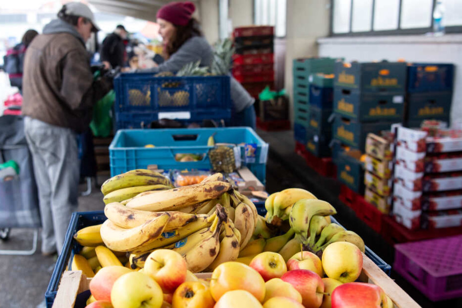 Ehrenamtliche Helfer der Münchner Tafel verteilen an der Ausgabestelle am Großmarkt Lebensmittel an die Gäste.