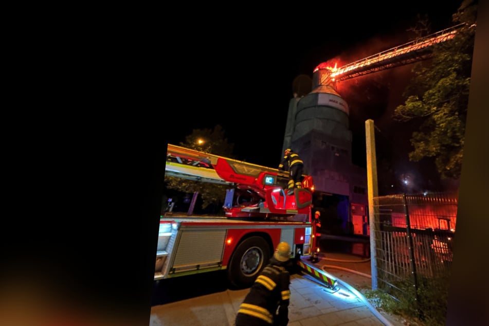 Die Feuerwehr kämpft gegen die Flammen, die aus einem Mischsilo schlagen.