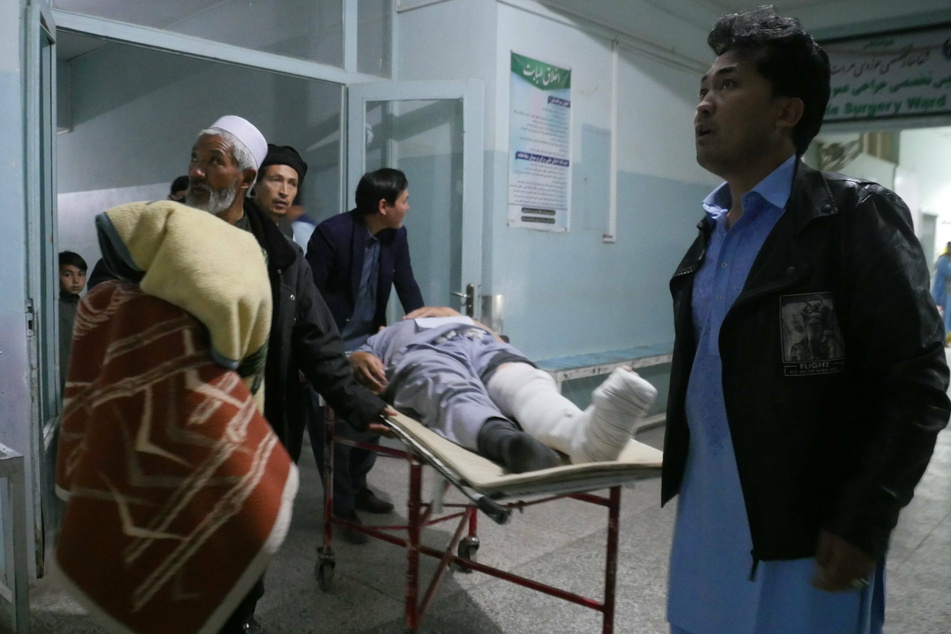 People carry an injured man to a hospital after a bomb attack in Herat, Afghanistan, on April 1.