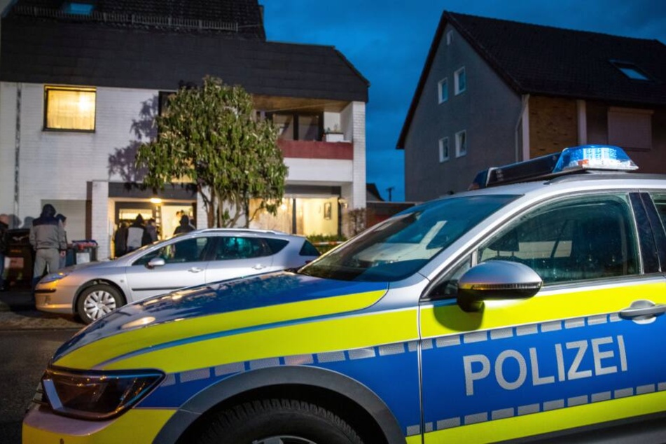 Ein Streifenwagen der Polizei parkt vor einem Mehrfamilienhaus.