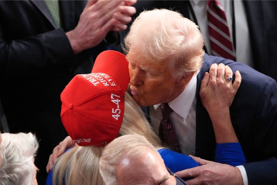 President Donald Trump kisses Rep. Marjorie Taylor Greene after addressing a joint session of Congress at the US Capitol in Washington DC on March 04, 2025.