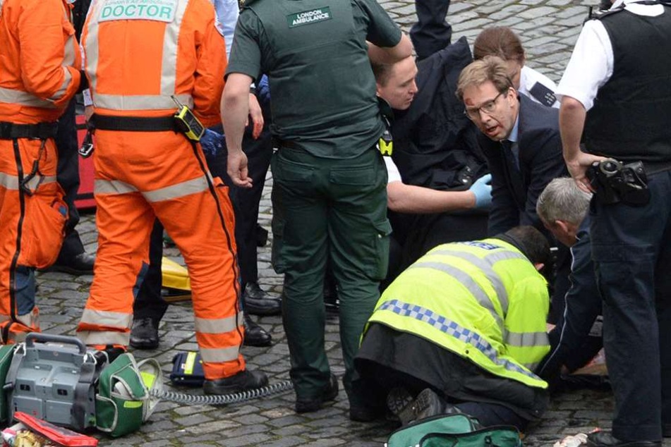 Sein Gesicht ist blutverschmiert, mit aller Macht versucht der Politiker Tobias Ellwood das Leben des Polizisten zu retten.