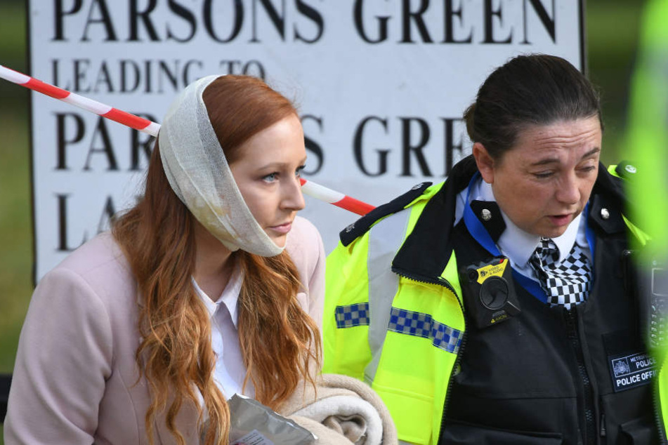 Eine verletzte Frau wird in der Nähe der U-Bahn Station Parsons Green, wo es eine Explosion gegeben hat, von einer Polizistin begleitet.