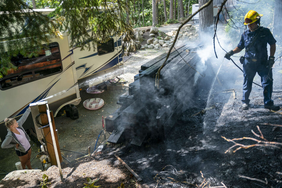 Ein Feuerwehrmann des Department of Natural Resources löscht einen Holzstapel in Bellingham.