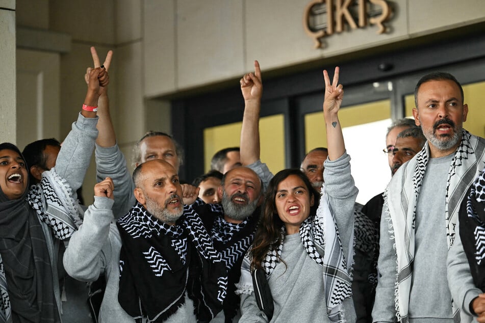 Members of the Global Sumud Flotilla headed for Gaza and arrested and deported by Israel pose outside a terminal following their arrival at Istanbul Airport on May 21, 2026.