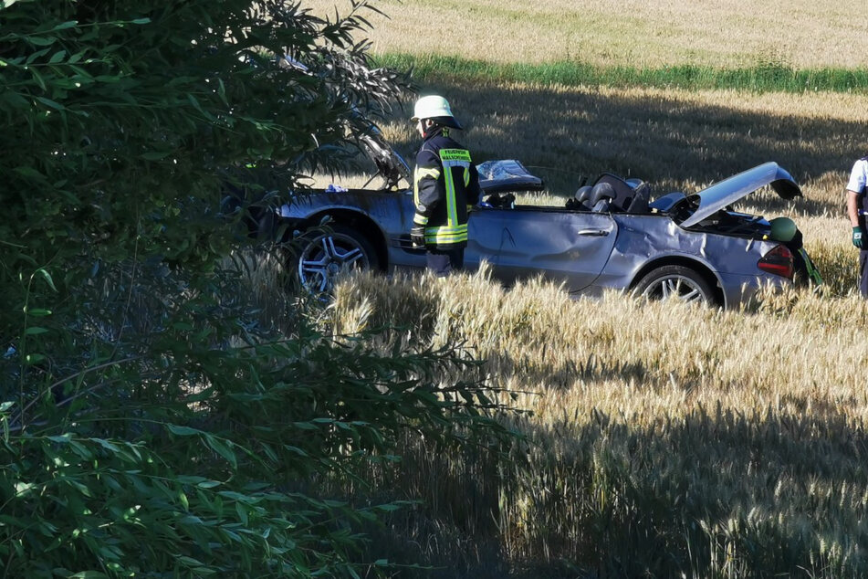 Die Feuerwehr begutachtet den Mercedes-Cabrio, mit dem der Fahrer sich überschlagen hatte.