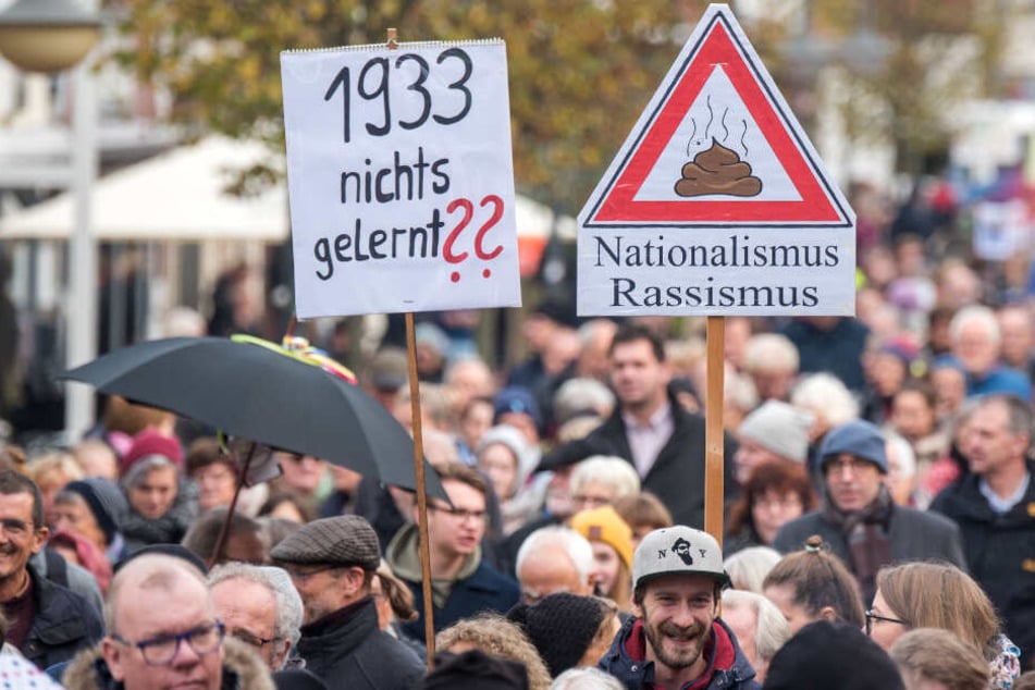 Teilnehmer der Demonstration halten Schilder gegen Neonazis hoch.