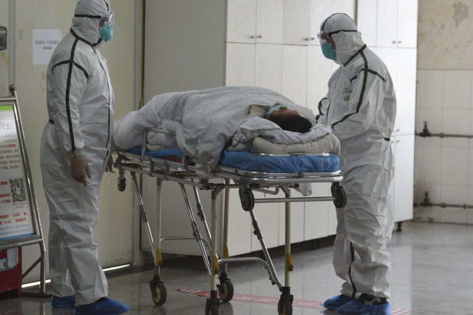 Medizinisches Personal in Schutzanzügen verlegt einen Coronavirus-Patienten in eine Isolierstation in China. (Archivbild)