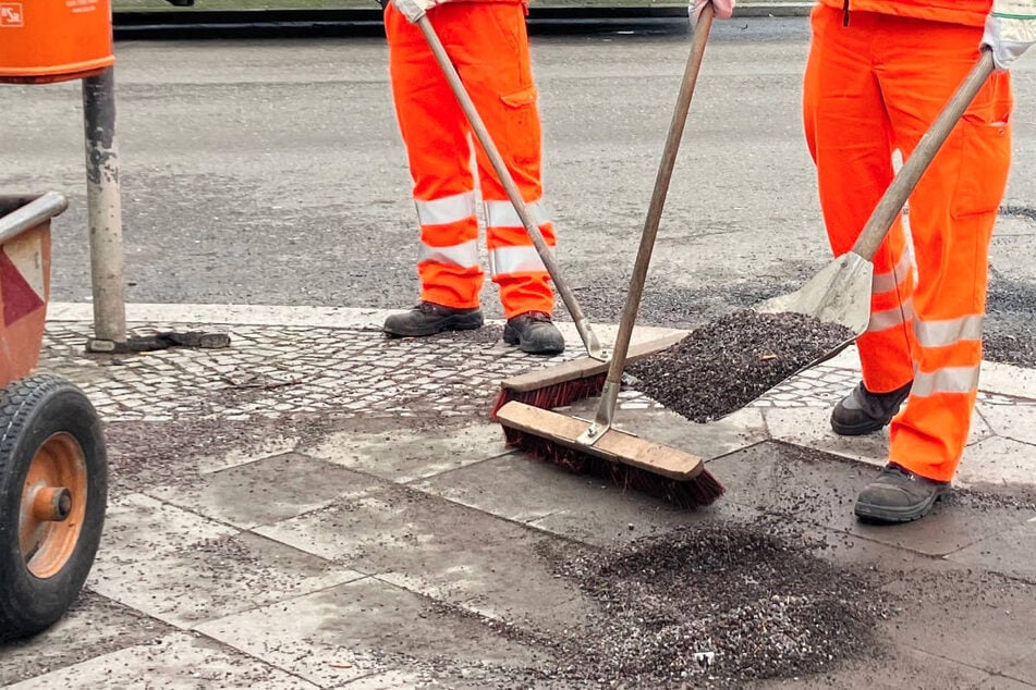 Die Mitarbeiter der Berliner Stadtreinigung haben alle Hände voll zu tun, um den Rollsplitt von den Straßen und Gehwegen zu entfernen.