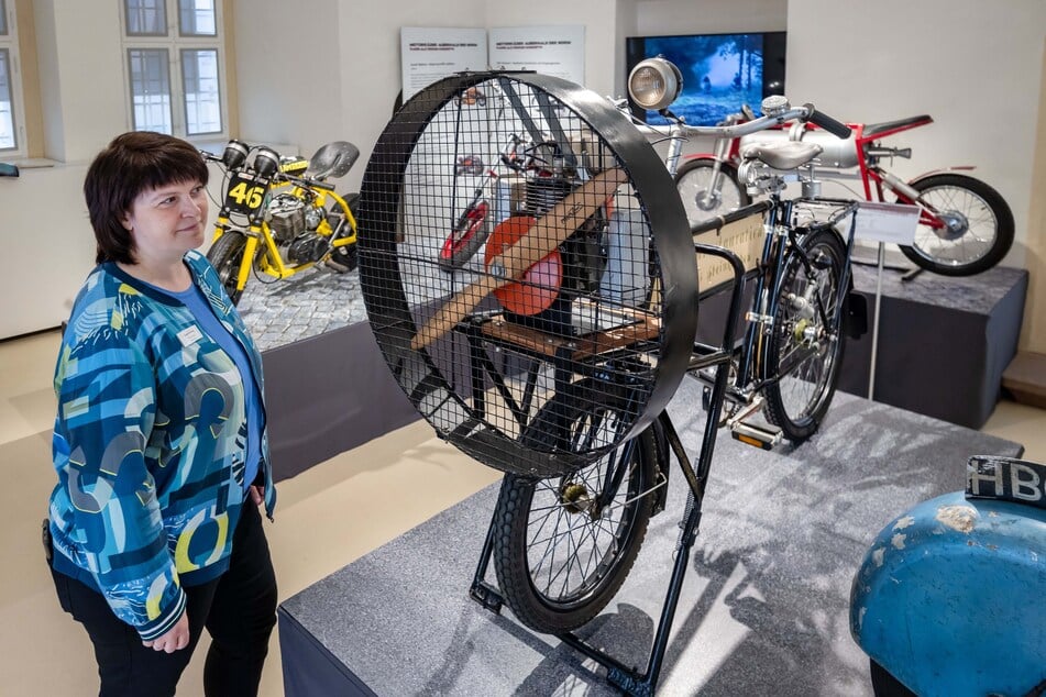 Mitarbeiterin Tina Kurz betrachtet das Lastenfahrrad mit Propellerantrieb.