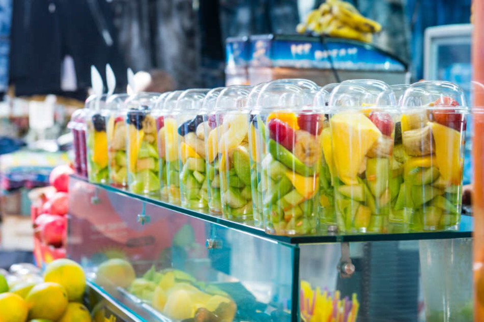 Fertig abgepackte Obstsalate stehen in einem Geschäft auf einem Tresen.