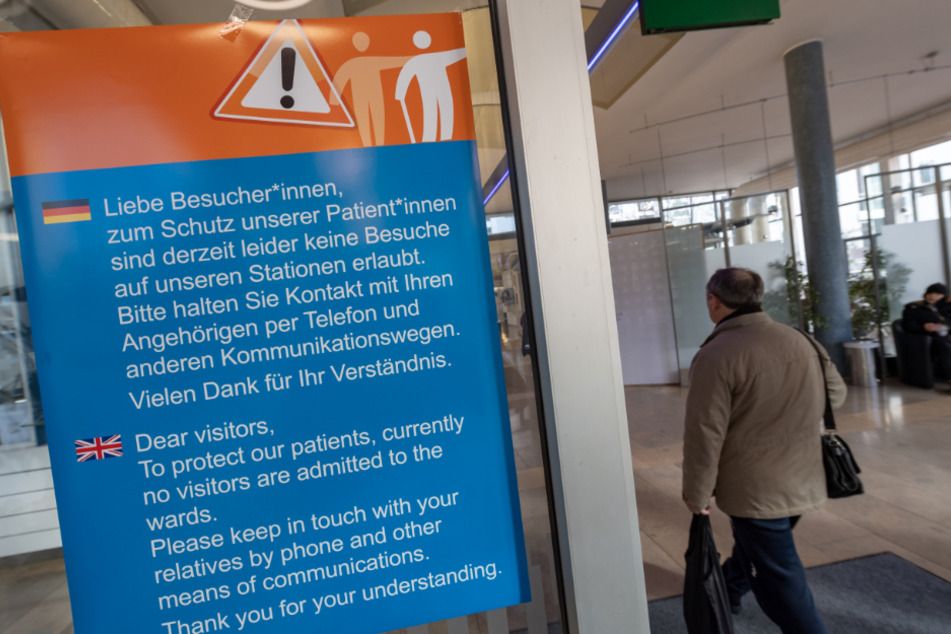 Ein Hinweisschild hängt an einer Klinik in München.