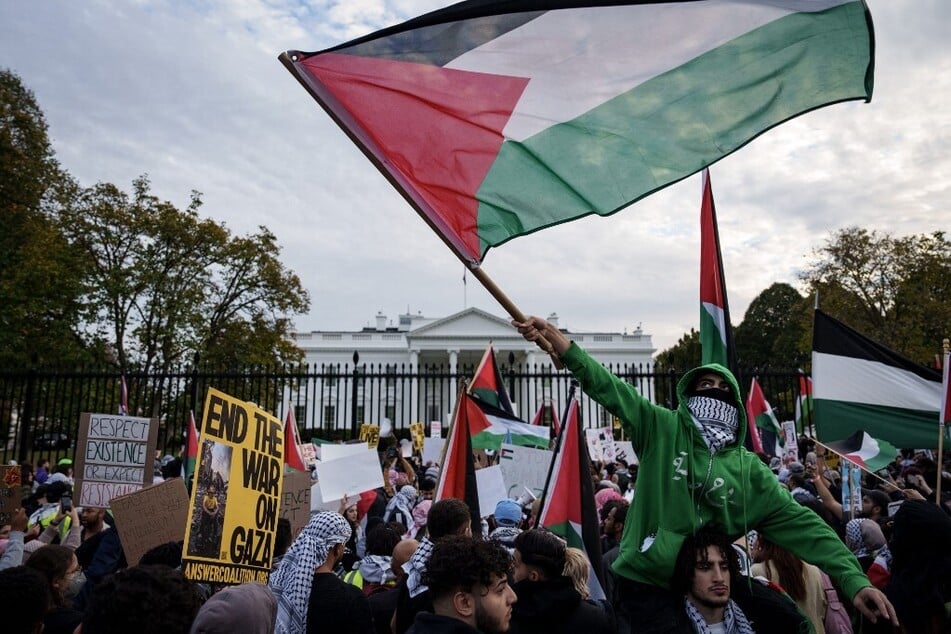 Demonstrators fly Palestinian flags outside the White House during the National March on Washington for Palestine.