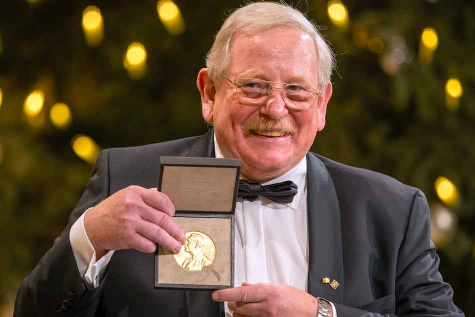 Reinhard Genzel (68), deutscher Physiker, hält bei der Übergabe des Nobelpreises für Physik die goldene Medaille in seinen Händen.