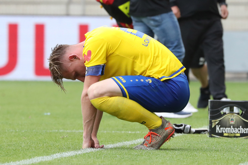 Aufstieg mit Lok Leipzig in die 3. Liga verpasst, enttäuscht hockt Robert Zickert auf dem Rasen.