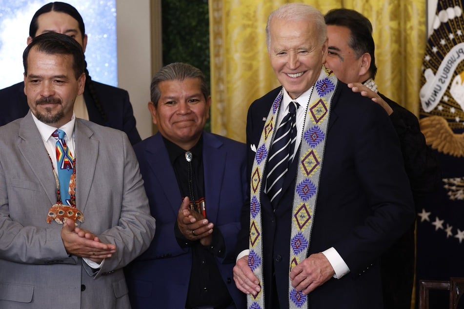 President Joe Biden is given a ceremonial sash after singing proclamations creating the Chuckwalla National Monument and the Sáttítla Highlands National Monument in the East Room at the White House on Tuesday.