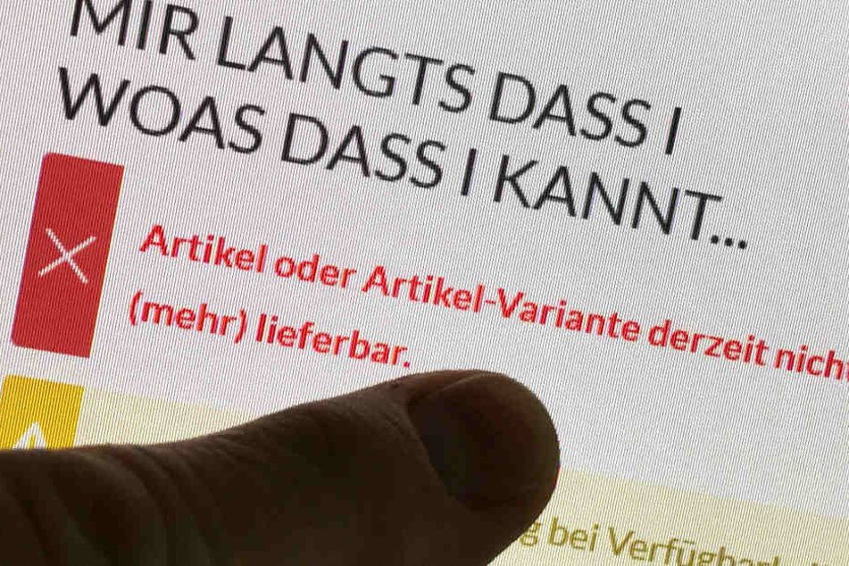 Auf einem Monitor ist auf der Internetseite eines Anbieters zu sehen, dass T-Shirts mit dem Aufdruck "Mir langts dass i woas dass i kannt wenn i woin dad" derzeit nicht verfügbar sind.